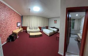 アルマトイにあるZolotoi Drakon Hotelのベッド2台とバスルームが備わるホテルルームです。