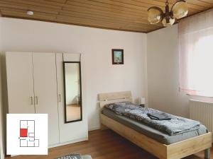 um quarto com uma cama, um espelho e um tecto em Monteurzimmer/ Ferienwohnung Kati em Albstadt
