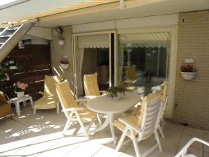 un patio con mesa y sillas en un porche en Apartment Seastar Zandvoort, en Zandvoort