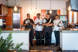 a group of men standing in a kitchen holding instruments at Unembeza Boutique Lodge & Spa in Hoedspruit