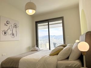 a bedroom with a large bed with a large window at Cloud Number 10 in Beirut