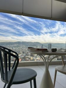a table and chair on a balcony with a view at Cloud Number 10 in Beirut