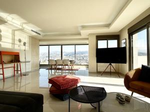 uma sala de estar com uma televisão e uma mesa e cadeiras em Cloud Number 10 em Beirute