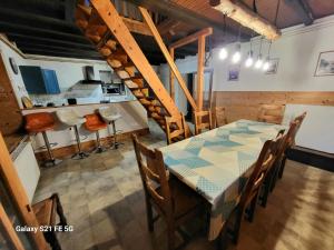 ein Esszimmer und eine Küche mit einem Tisch und Stühlen in der Unterkunft Gîte du Grand Cher in Les Rousses