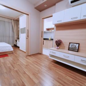 a bedroom with white cabinets and a bed and wooden floors at CBP treasure swimming condo in Chiang Mai