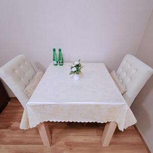 a table with three green bottles and flowers on it at CBP treasure swimming condo in Chiang Mai +1 photo