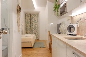 una cucina bianca con un lavello e un forno a microonde di Guesthouse by Trip2Portugal a Lisbona