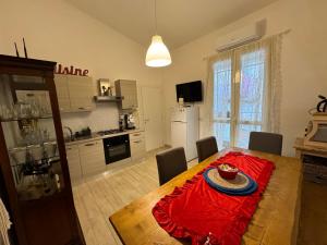une cuisine et une salle à manger avec une table et un tissu de table rouge dans l'établissement La casa di Sarah aspetta voi, à Naples
