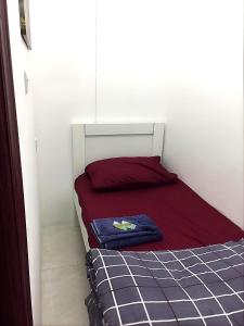 Dormitorio pequeño con cama de color rojo y azul en Heart of Abu Dhabi - Pearl Room, en Abu Dabi