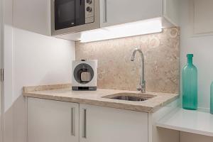 una cucina con lavello e microonde di Guesthouse by Trip2Portugal a Lisbona