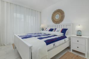 ein weißes Schlafzimmer mit einem Bett und einem Spiegel in der Unterkunft Apartament Ambra Marina - Basen & SPA in Dziwnów + 52 Fotos