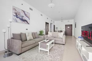 a living room with two couches and a table at VayK - Stunning 1BD with Full Sea View on the Palm in Dubai