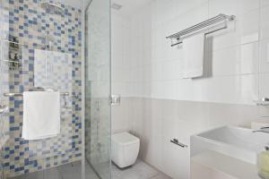 a white bathroom with a toilet and a sink at VayK - Stunning 1BD with Full Sea View on the Palm in Dubai