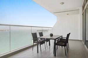 a dining room with a table and chairs and the ocean at VayK - Stunning 1BD with Full Sea View on the Palm in Dubai