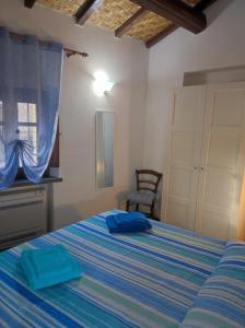 - une chambre avec un lit et 2 serviettes bleues dans l'établissement Casa Lalletta, à Nurachi