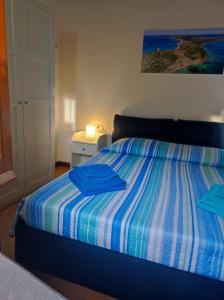 - une chambre avec un lit doté de 2 chemises bleues dans l'établissement Casa Lalletta, à Nurachi