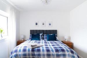 a bedroom with a blue and white bed with blue pillows at 3 Bed House Buckie Contractors Business Travellers in Buckie
