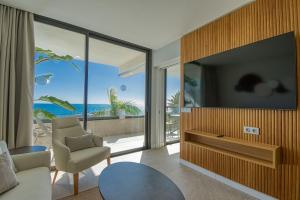a living room with a tv and a couch and a chair at RELAXIA BEVERLY SUITES in Playa del Ingles
