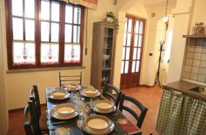 a dining room table with chairs and plates on it at Natura & Relax a Casa Trumlinot in Sanfront