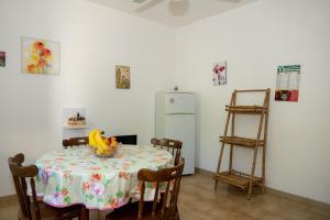 uma sala de jantar com uma mesa e um frigorífico em A casa di Franco e Rosa em Leuca