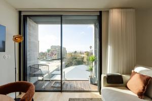 ein Wohnzimmer mit einer Glasschiebetür zu einem Balkon in der Unterkunft Feel Porto Corporate Housing Boavista in Porto