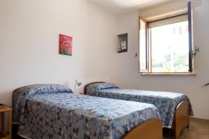 a room with two beds and a window at A casa di Franco e Rosa in Leuca