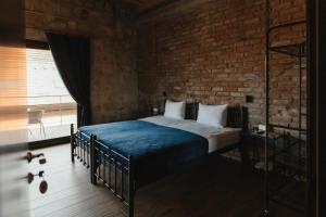 a bedroom with a bed and a brick wall at Crama Mircesti 