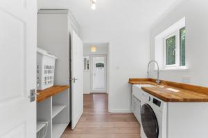 a laundry room with a washer and dryer at Woodland Retreat - Garden - Sleeps 11 in Gaywood