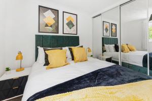 a bedroom with a large bed with yellow pillows at Stunning Retreat - Parking - Garden - Sleeps 11 in Gaywood