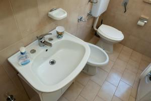 a bathroom with a white sink and a toilet at A casa di Franco e Rosa in Leuca +13 photos