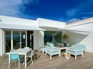 a patio with a table and chairs on a deck at Villa del Mar Lanzarote - Luxury Beachhouse in Arrecife