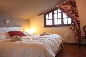 a bedroom with a large white bed with a window at Natura & Relax a Casa Trumlinot in Sanfront