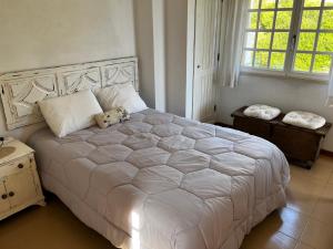 a bedroom with a white bed with a teddy bear on it at Lighthouse - House with amazing sea views in São Martinho do Porto