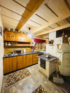 une cuisine avec des placards en bois et un four en pierre dans l'établissement Bacówka u Bobika, à Waksmund
