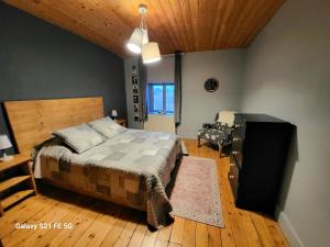 a bedroom with a bed and a television in it at Gîte du Grand Cher in Les Rousses