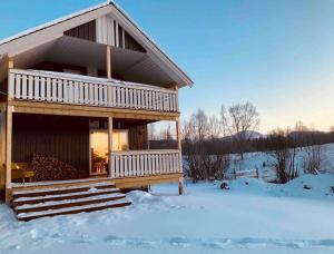 Cabaña de madera en la nieve con suelo cubierto de nieve en Vestermo farm house, en Brandvoll