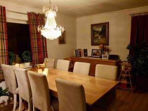 uma sala de jantar com uma mesa de madeira e um lustre em Vestermo farm house em Brandvoll