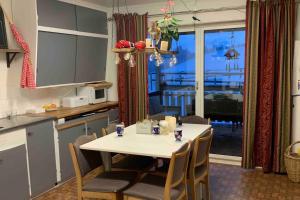 a kitchen with a table and chairs and a kitchen with a view at Vestermo farm house in Brandvoll