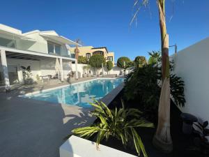 a swimming pool in front of a house at Villa del Mar Lanzarote - Luxury Beachhouse in Arrecife