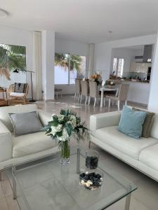 una sala de estar con 2 sofás blancos y un jarrón de flores en Villa del Mar Lanzarote - Luxury Beachhouse en Arrecife