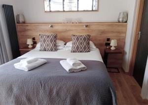 a bedroom with a bed with two towels on it at Cherry Bird Country Park in Newbury