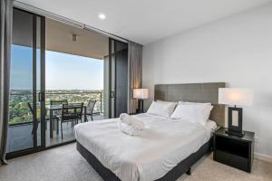 a bedroom with a large bed and a balcony at Stunning cityview 1BR Apt, 1 min to train in Brisbane