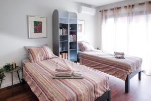 1 dormitorio con 2 camas y estante para libros en Taste Tavira (by Annick) fully equipped apartment, tastefully decorated, perfect location and free parkingric center of the city of Tavira., en Tavira