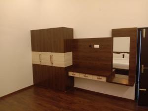 a dressing room with a mirror and a wooden cabinet at Tulip in green meadows in Yercaud