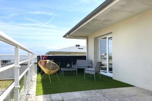 a patio with chairs and a table on a balcony at Le Rooftop - Terrasse - Parking - Piscine in Caen