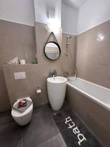 ein Badezimmer mit einer Badewanne, einem WC und einem Waschbecken in der Unterkunft Cozy 1 bedroom apartment! in Bukarest