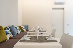 a dining room with white tables and chairs at Marna Relais in Sirolo