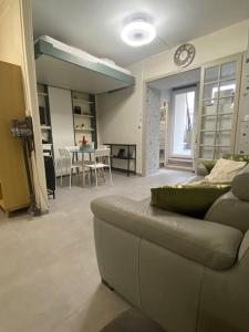 ein Wohnzimmer mit einem Sofa und einem Tisch in der Unterkunft Studio cosy avec piscine in Martigues