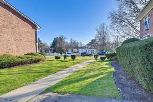 a sidewalk next to a brick building with a hedge at Cozy Bay Shore Condo Near Museums and Outdoor Rec! in Bay Shore