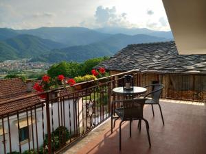 a balcony with a table and chairs and mountains at Natura & Relax a Casa Trumlinot in Sanfront
